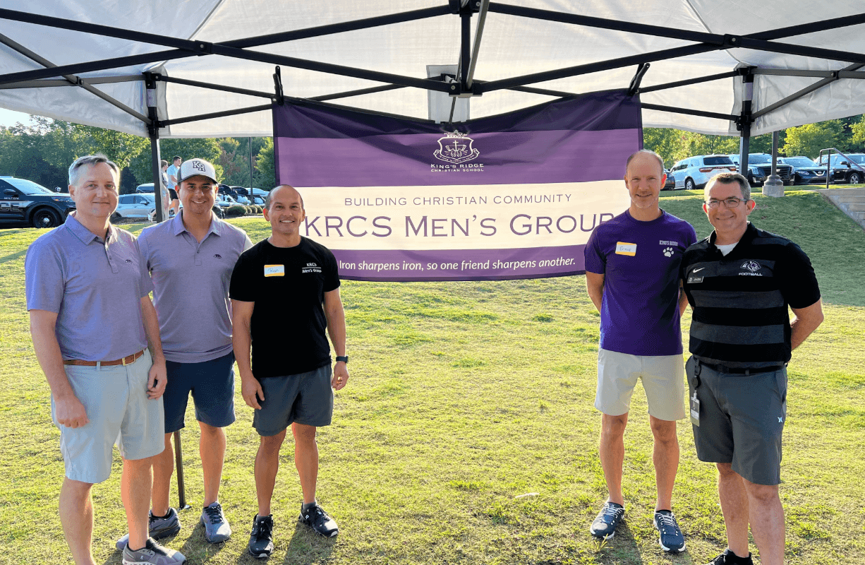 KRCS Men's Group gathered under the group banner at a community event